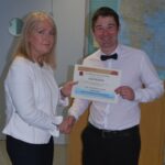 Photograph of Steering Group Representative awarding a certficate