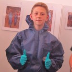 Schoolboy in protective clothing gives thumbs-up 