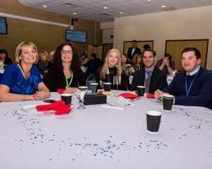 Smiling attendees around a table
