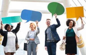 4 people holding up speech bubbles 