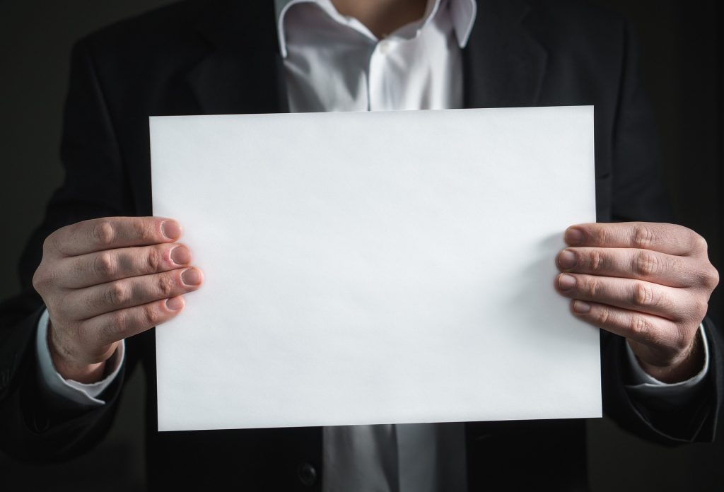 man holding up blank sheet of paper