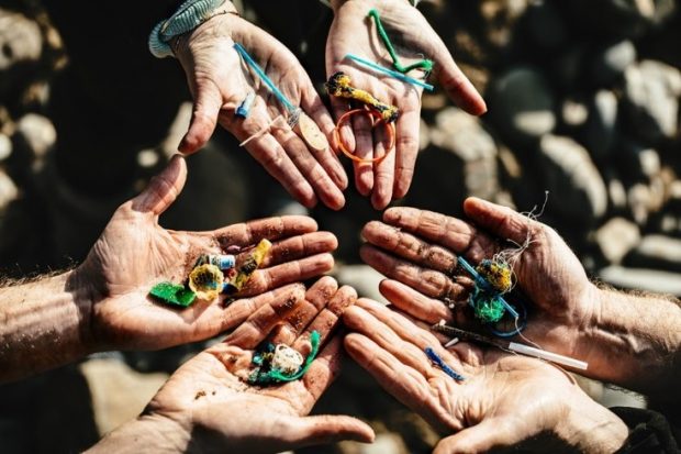 hands held out holding pieces of plastic