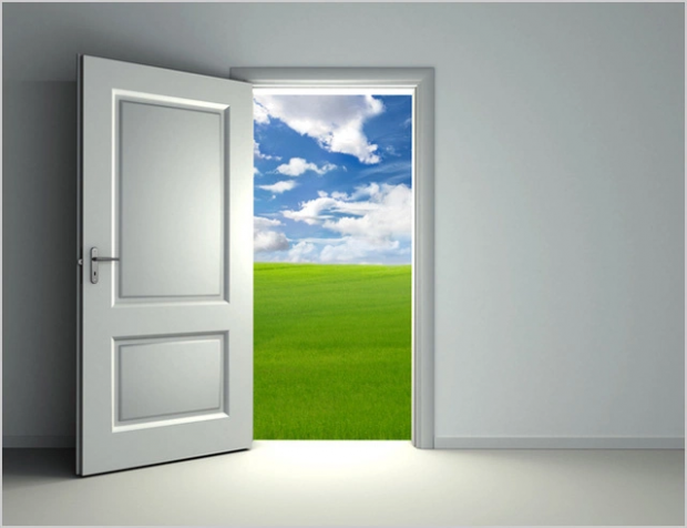 Open door showing grass and clouds the other side