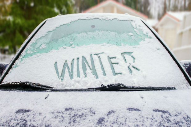 A car covered in frost with the word winter etched on the windscreen in capital letters