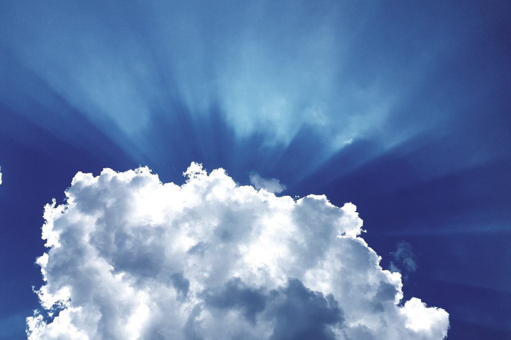 sun rays through white cumulus clouds