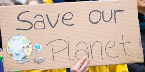 A brown Board with writing on Save our Planet with a little globe sign on right hand side corner 