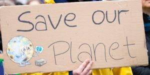 A cardboard sign saying 'save our planet'