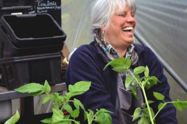 a woman laughing while potting plants 