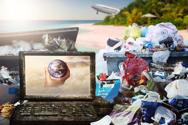 computer screen with world in hand and rubbish left on beach at righthand side and aircraft in background