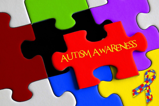 multi colour jigsaw pieces with autism awareness written in centre