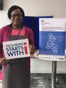 A picture of Bernadette Thompson OBE holding a sign saying "Inclusion starts with I"