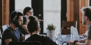 People sat around a table working on laptops