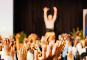 a room of people with raised hands