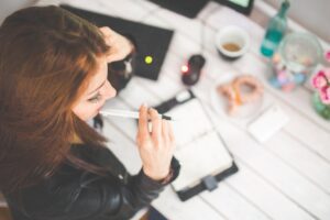 A woman sat her desk thinking